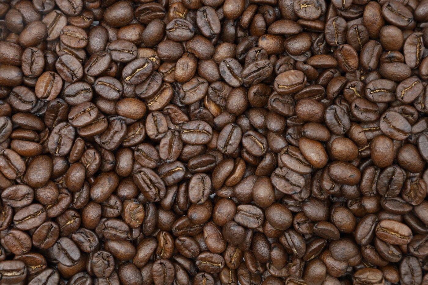 حبوب قهوة محمّصة تُعرض كمرجع للمادة المصدر.